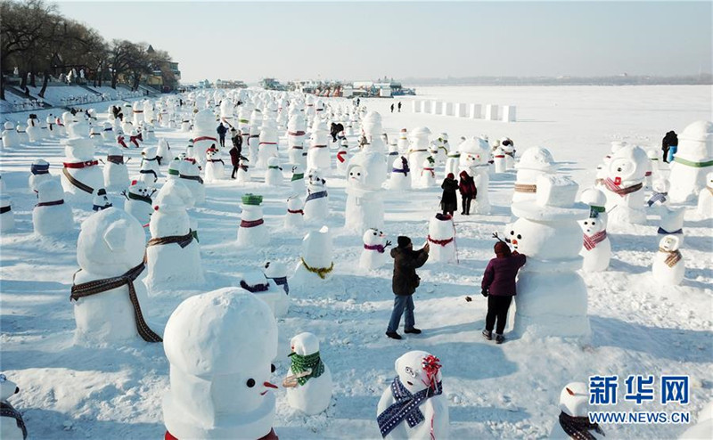 1月2日，市民、游客在雪人群中游玩觀賞（無(wú)人機(jī)拍攝）。2019個(gè)各式各樣的雪人，近日在冰城哈爾濱市的松花江畔亮相，引來(lái)眾多市民游客游玩觀賞。新華社記者 王建威 攝